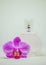 A bottle of perfume and an orchid flower.