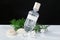 Bottle of perfume, sea shells and pearls on table against black background