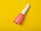 A bottle of pink nail polish on a bright yellow background. Top view. Manicure for nails