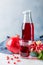 Bottle with pomegranate juice and a glass, ripe pomegranate, whole and peeled on a white background