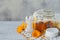 A bottle of pot marigold tincture or infusion with fresh calendula flowers and a cotton pad and sticks on white background.