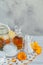 A bottle of pot marigold tincture or infusion, ointment, cream or balm with fresh and dry calendula flowers and cotton pad and