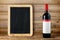 Bottle of red wine and blank blackboard