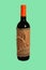 Bottle of red wine wrapped in burlap tied with twine isolated on trendy aqua menthe color background. Holidays concept