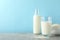 Bottle of rice milk, glass of rice milk, rice plate on grey table again blue background