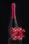 Bottle of rose sparkling wine with romantic gift and red bow. Vertical format. Isolated on black. Romantic present