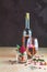 Bottle of rose wine and glass served with rose wine and rose petals, rose and candied fruit in glass on pink concrete table and