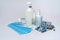 Bottle of sanitizer or liquid soap, protective mask, medicine pills blisters and thermometer over light grey background