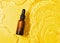 Bottle serum oil cosmetic in clean transparent water with sunlight on yellow background