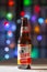 A Bottle of Tecate Beer. A Mexican beer on a white texture surface on a colourful defocused lights.