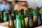 Bottle tops of open glass bottles with blurred background. Glowing clear glass bottlenecks. Green and brown glass beer bottles