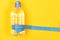 Bottle of water and fitness equipment on yellow background