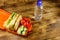 Bottle of water and lunch box with sandwiches and fresh vegetables on wooden table