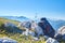 A bottle of water near a backpack and a panama hat on a rock in the mountains of mountains in the right corner