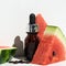 A bottle of watermelon seed oil. Packaging of natural essential oil or serum for the face with watermelon on a white background.
