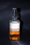 Bottle of whiskey half full on a black background. Bottle in a man\'s hand. Single malt whiskey. Alcohol. A bottle of whiskey from