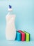 Bottle with white dishwashing liquid and three foam sponges of different colours on a blue background. Kitchen detergent.