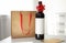 Bottle of wine, card and paper bag on table