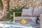 Bottle of wine, empty glasses, fruits, and journals on an outdoor table in front of a couch