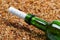 Bottle of wine with help message on sand in beach at sun summer