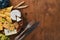 A bottle of wine, and a large assortment of cheeses, honey, nuts and spices, on a wooden table. Top view.