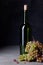 Bottle of wine with ripe grapes. Sommelier background. Copy space, dark background.