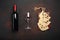 Bottle of wine, two glasses and maasdam cheese sliced on a cutting board on rusty background