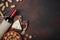 Bottle of wine, walnut, blue cheese, almonds, corkscrew and corks, on rusty background top view