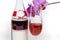 Bottle and wineglass of red sparkling wine against orchid closeup