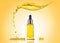 The bottle of the yellow cosmetic oil with big splash above and many splashes around