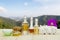 Bottles of aromatic oils with candles, pink orchid, stones and white towel on vintage wooden floor on blurred mountain background