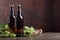 Bottles of beer, grain and hops on a old wooden table.