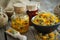 Bottles of calendula infusion, healthy marigold flowers in bowl and calendula salve on wooden table. Herbal medicine