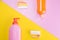 Bottles with cleaning liquids on two-color background, pink and yellow