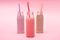 Bottles of colorful berry, strawberry and chocolate milkshakes with drinking straws