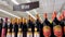 Bottles of dark wine on shelves in a retail grocery store and ceiling sign