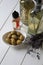 Bottles of different cooking oils, lavender flowers and olives on white wooden table