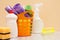 Bottles of dishwashing liquid, basket with garbage bags, brush and sponges on wooden desk