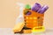 Bottles of dishwashing liquid, basket with garbage bags and sponges on wooden desk