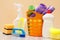 Bottles of dishwashing liquid, basket with garbage bags and sponges on wooden desk