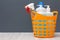 Bottles of dishwashing liquid in a plastic basket on gray background