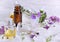 Bottles of essential oil and colorful petals of fresh wild  flowers