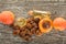 Bottles with essential oil, fresh apricots and pits on wooden table