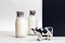 Bottles of fresh milk and figurine of a cow. Minimalistic still life of milk