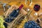 Bottles, glasses of wine, bunches of grapes and  corkscrew on  wooden table