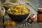 Bottles of homeopathic calendula granules, healthy marigold flowers in bowl and sack on wooden table. Homeopathy