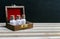 Bottles of homeopathy medicine standing in a row in old opened wood box on wood and dark background