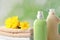 Bottles of laundry detergents, towels and beautiful flowers on blurred background, closeup