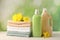 Bottles of laundry detergents, towels and beautiful flowers on white wooden table