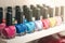 Bottles of multi-colored beautiful nail polish, placed in a row on a wooden shelf